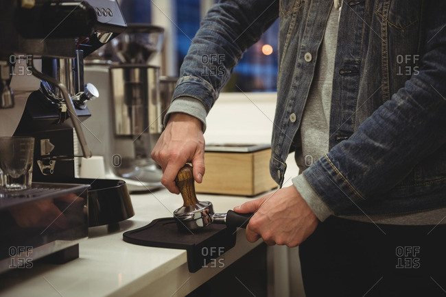 Person using a hand press espresso maker stock photo - OFFSET