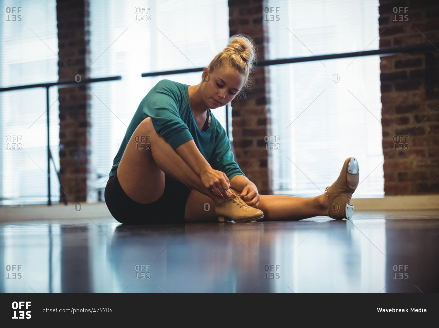 Woman tying shoelace in dance studio