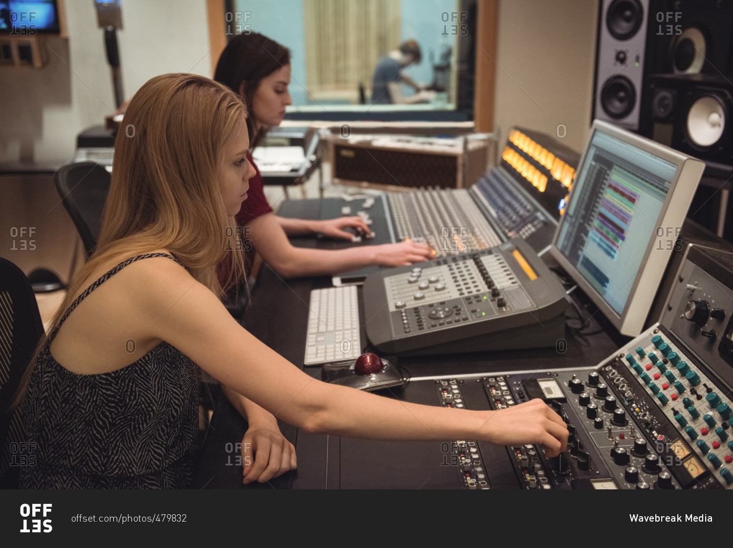 Audio engineers using sound mixer in recording studio stock photo - OFFSET