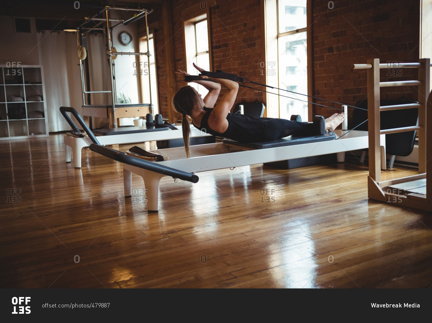 Determined woman practicing pilates in fitness studio