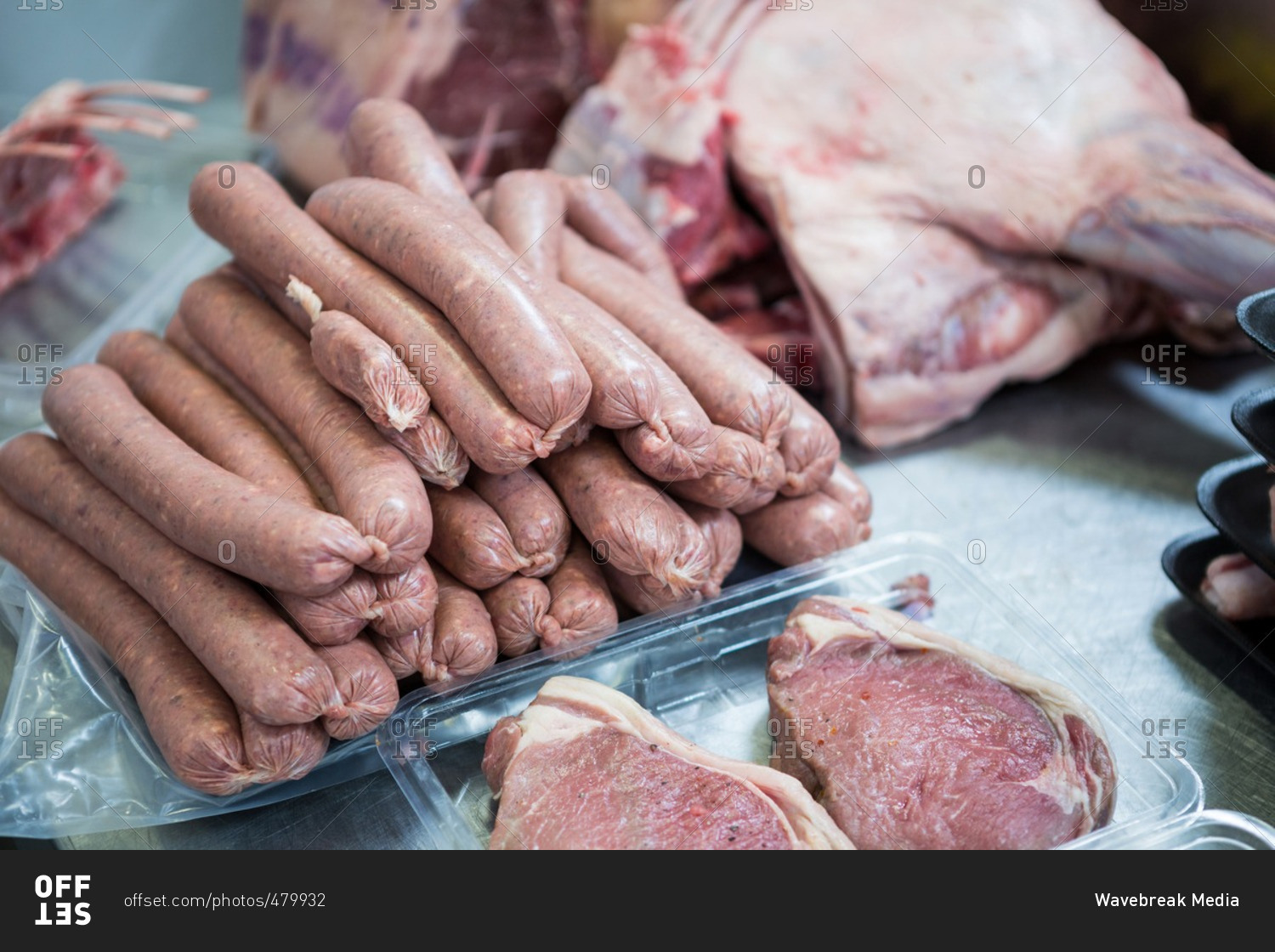 Close-up of raw sausages and meat in a plastic packaging tray at meat factory
