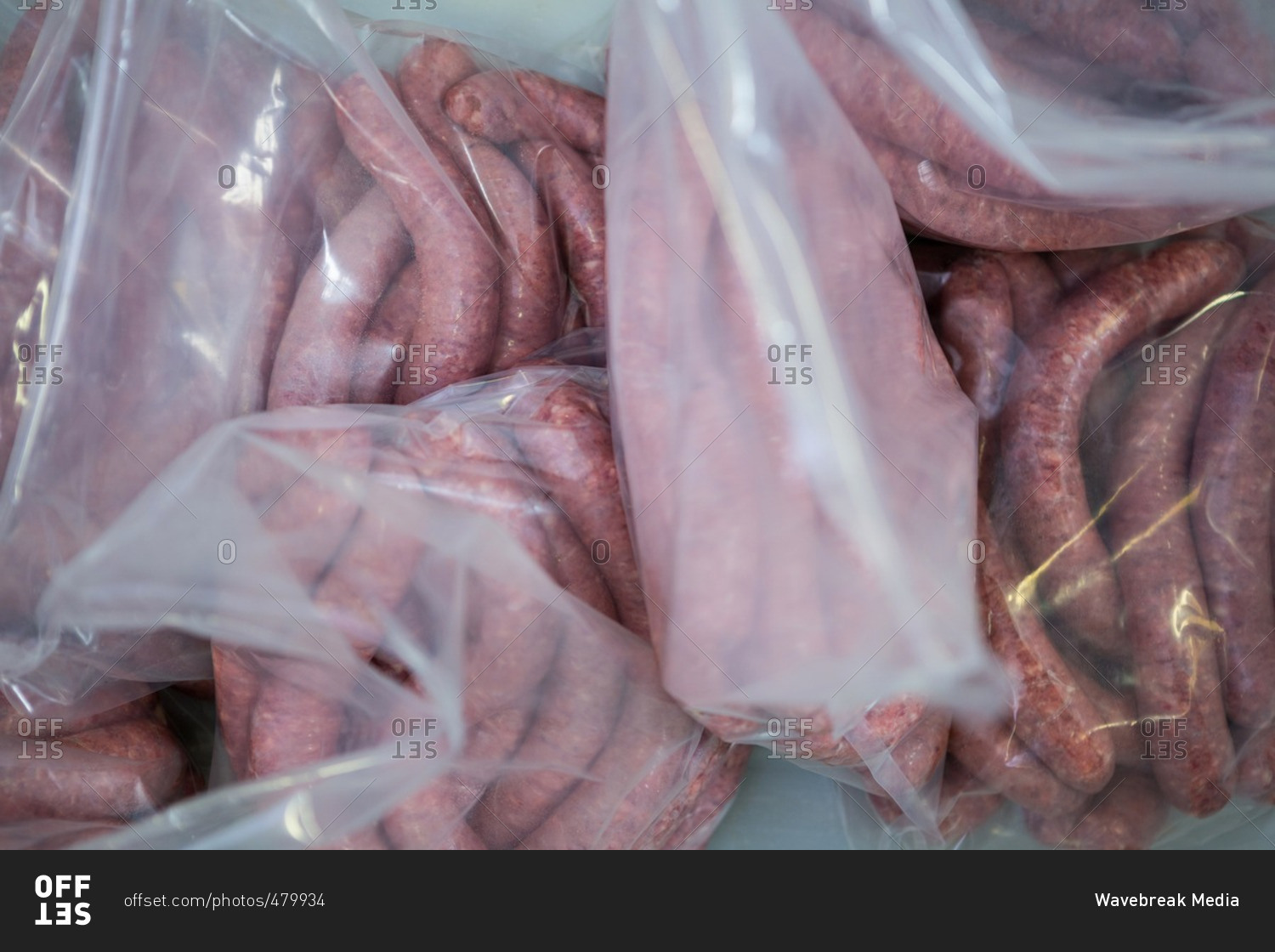 Close-up of raw sausages in a plastic packaging bag at meat factory
