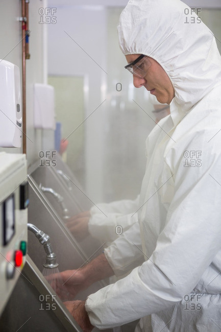 Technicians washing hands at hand wash basin at meat factory