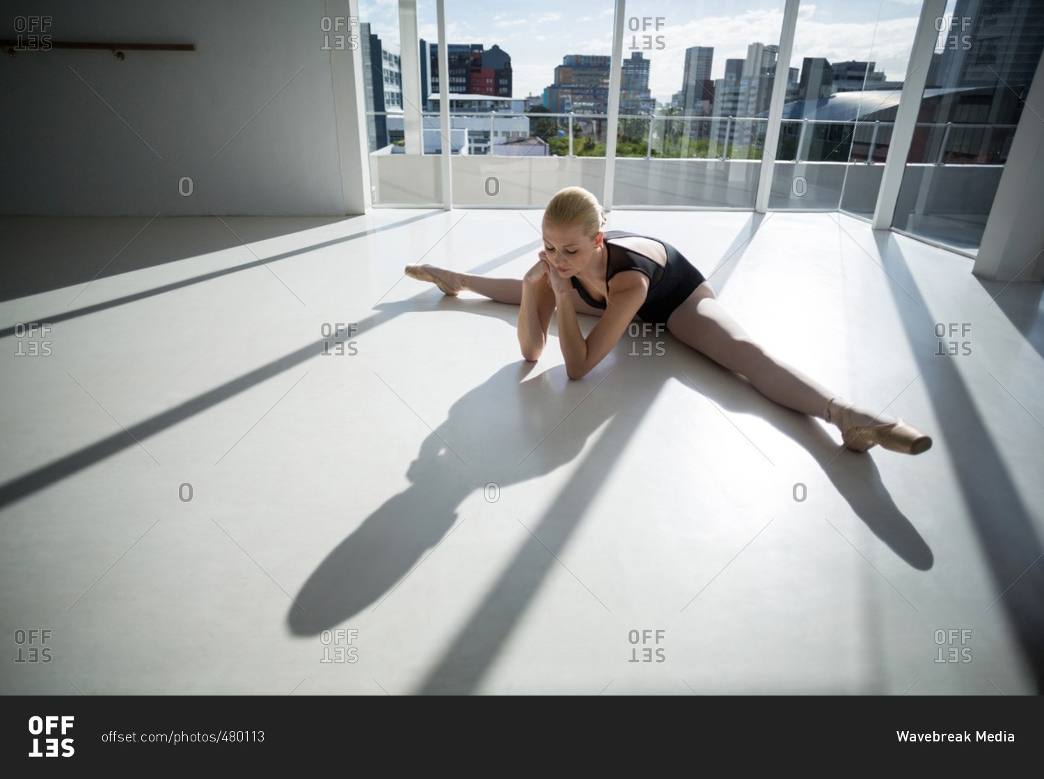Top view of ballerina stretching on the floor