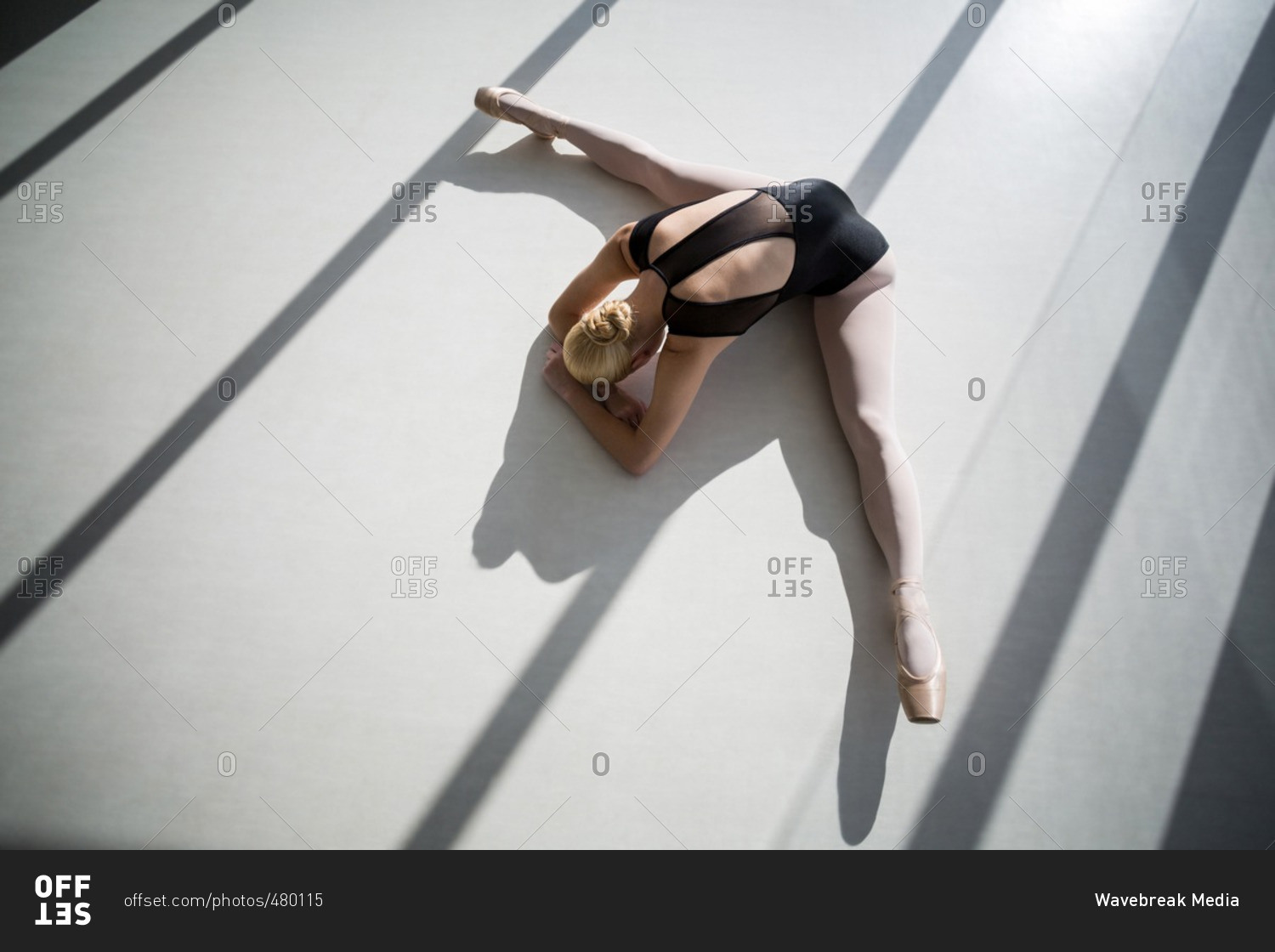 Top view of ballerina stretching on the floor