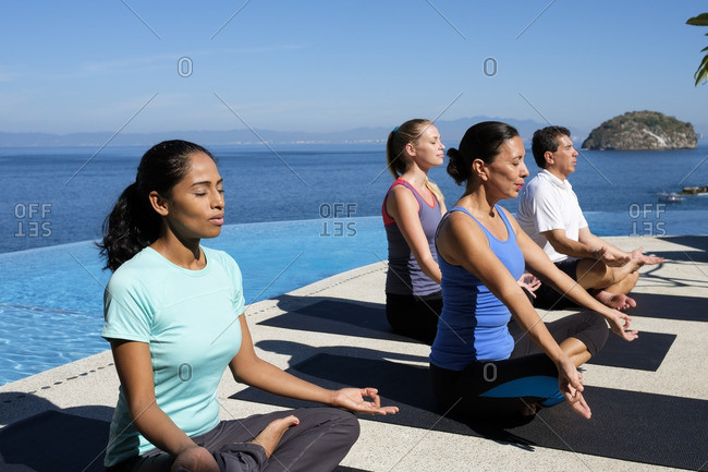 Yoga group exercising at ocean front resort