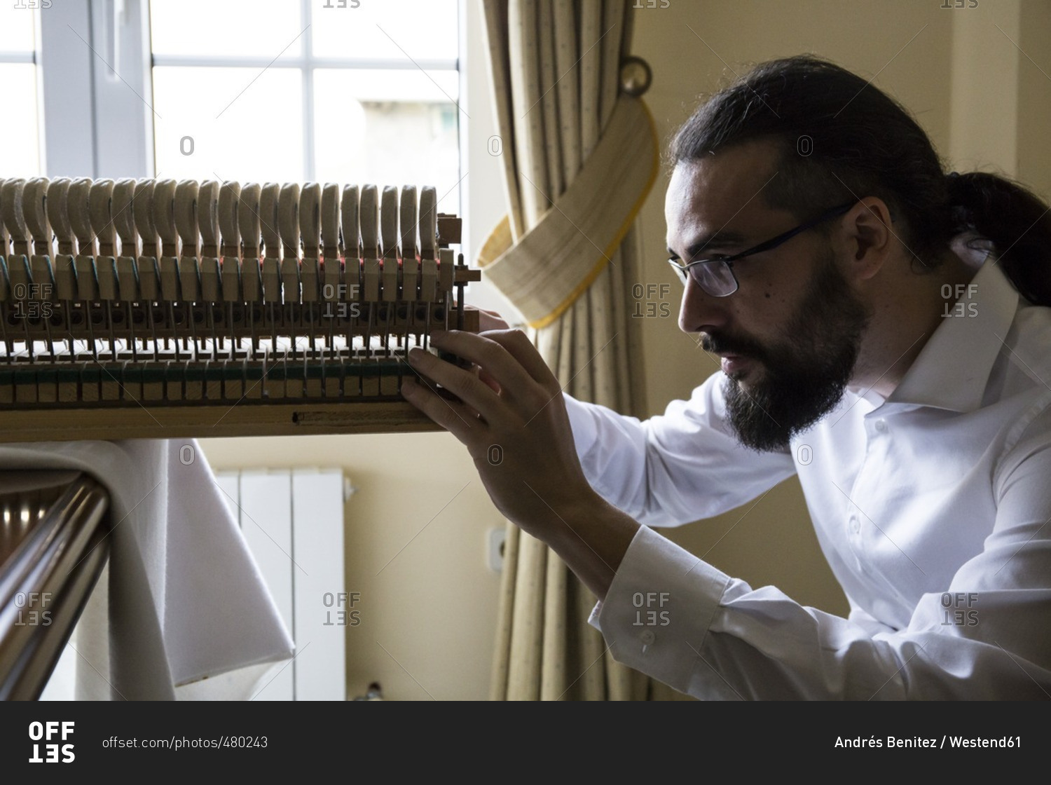 Piano tuner tuning grand piano stock photo - OFFSET