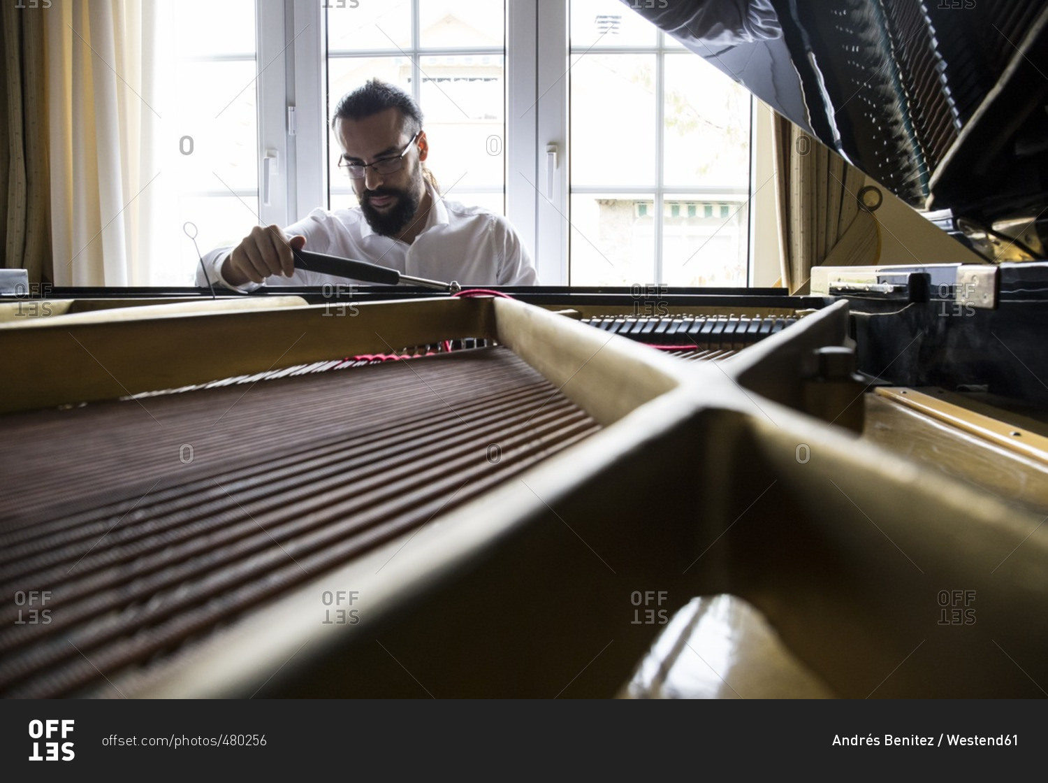 Piano tuner tuning grand piano stock photo - OFFSET