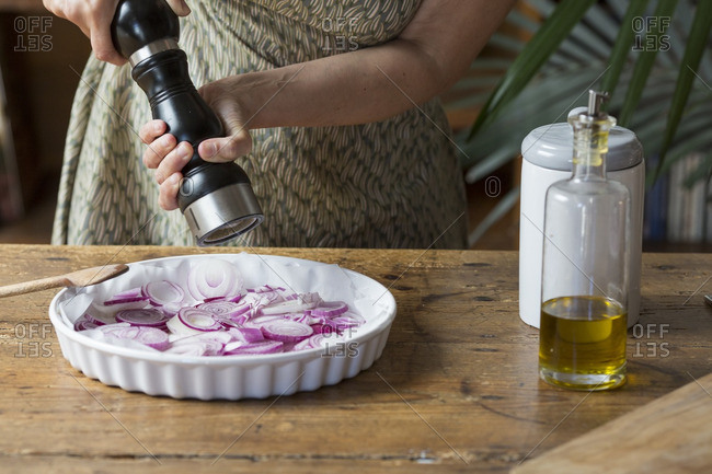 Woman preparing red onions for onion pesto