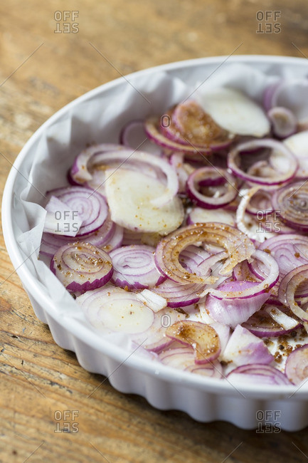 Red onions for onion pesto  in baking dish