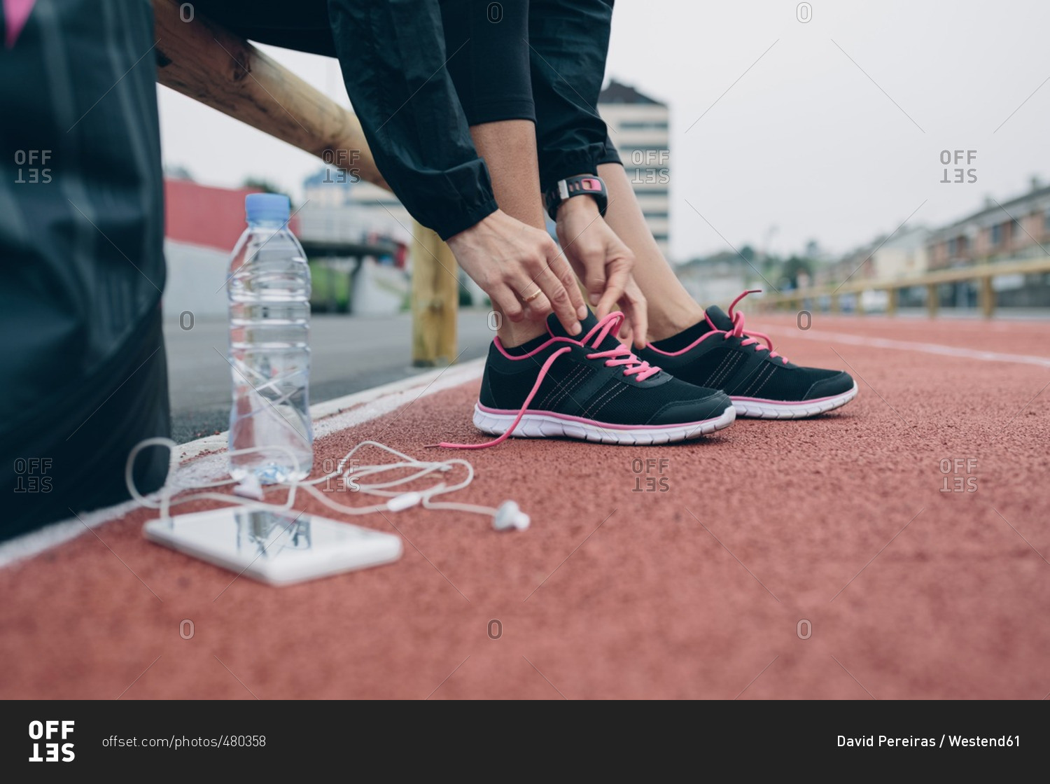 Woman on tartan track tying her shoes
