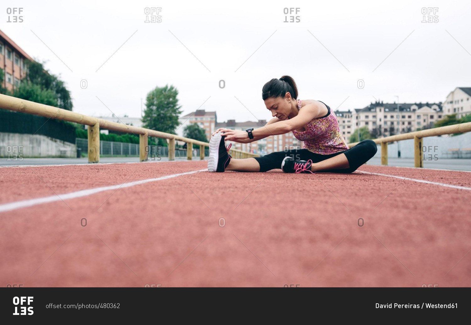 Woman stretching on tartan track
