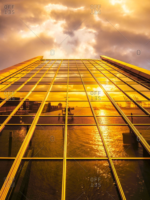Harbor reflecting on modern facade at sunset