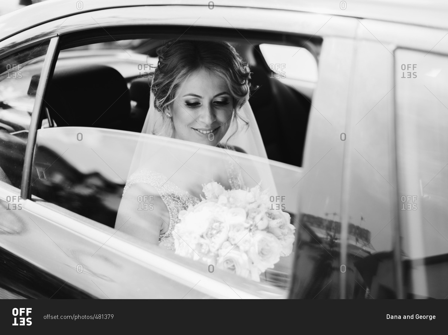 Bride with her bouquet in car stock photo - OFFSET