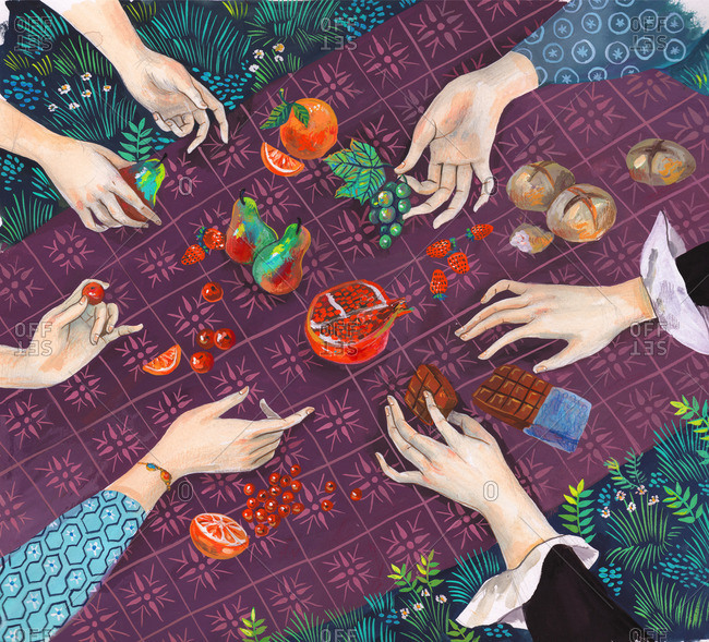 Hands picking fruits, bread and chocolates from a picnic blanket,