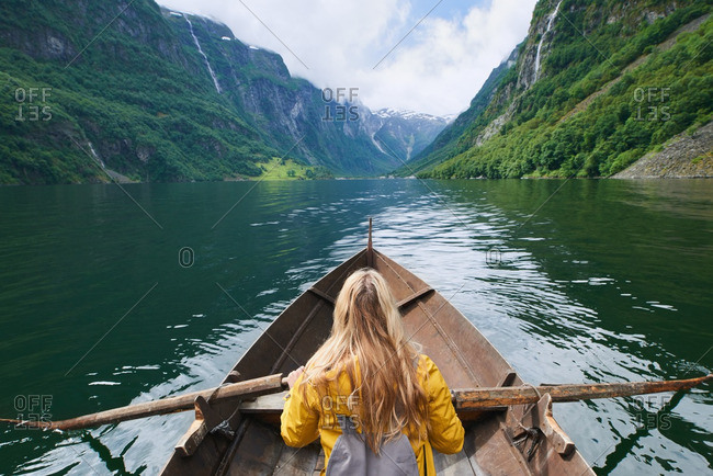 Woman enjoying majestic river view from row boat stock photo OFFSET