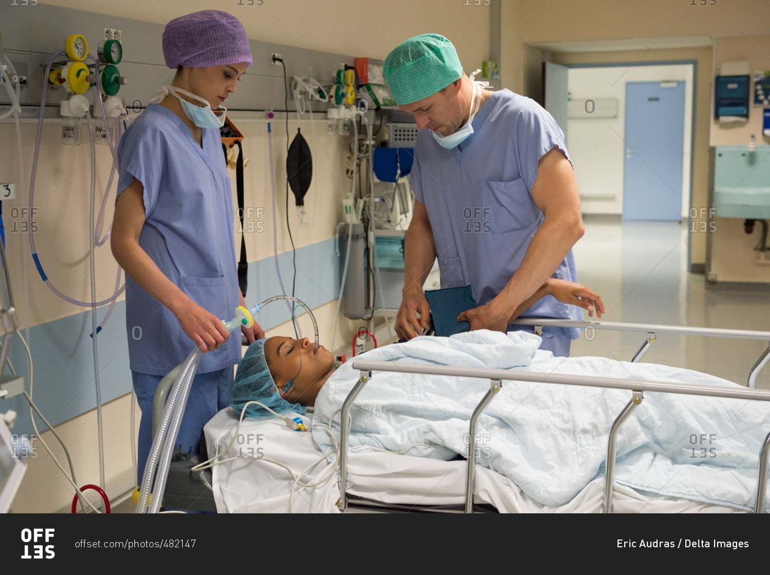 doctor-and-nurse-attending-a-patient-in-recovery-room-stock-photo-offset