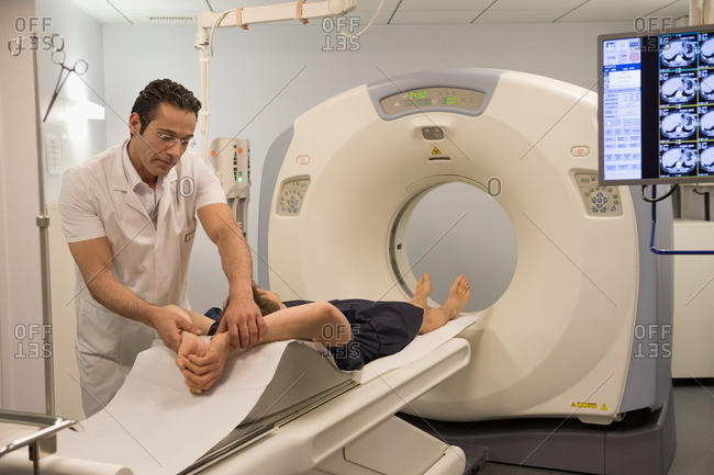 Male doctor preparing patient for MRI scan in hospital