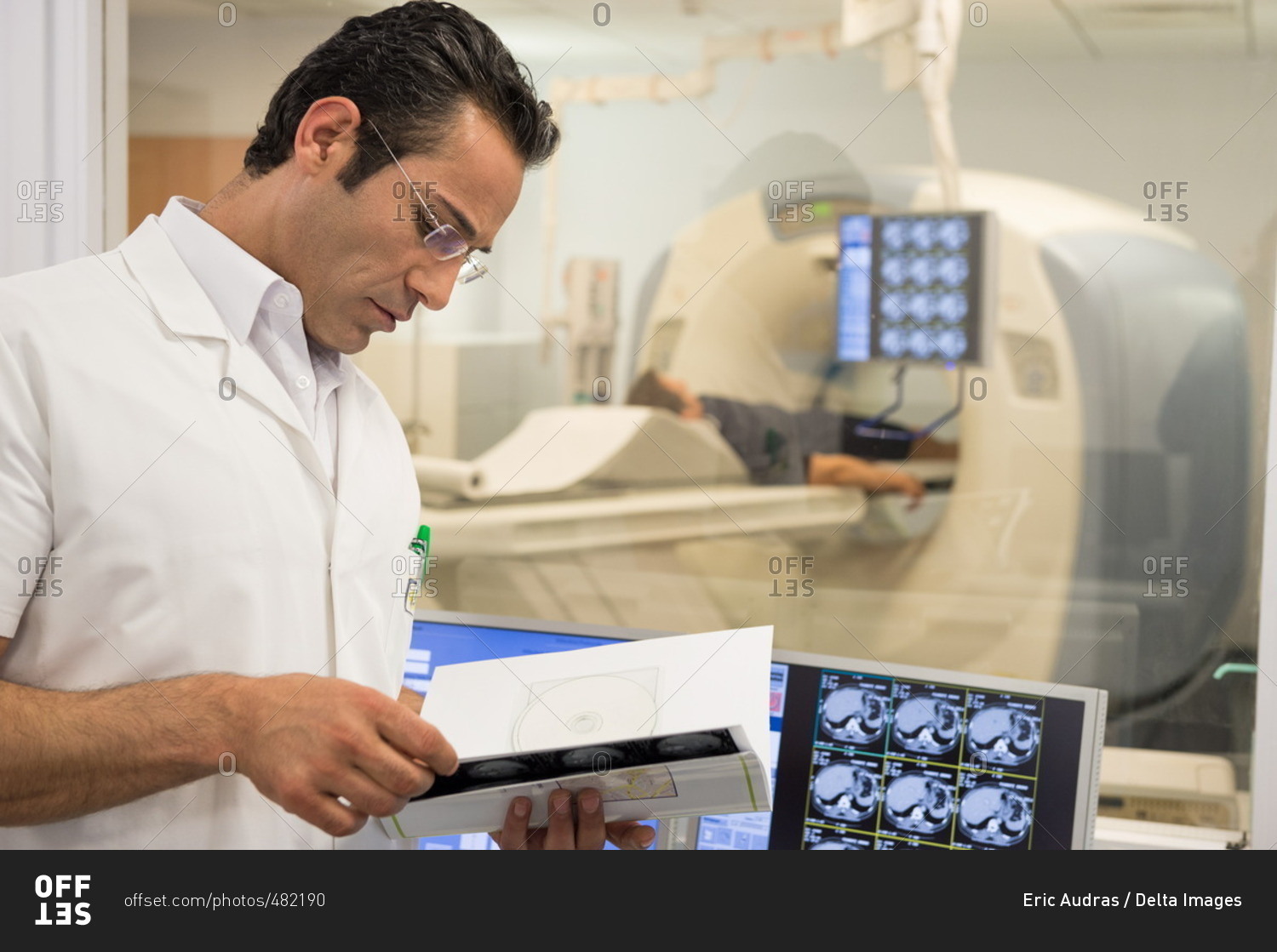 Male doctor examining MRI scan report in medical scan room