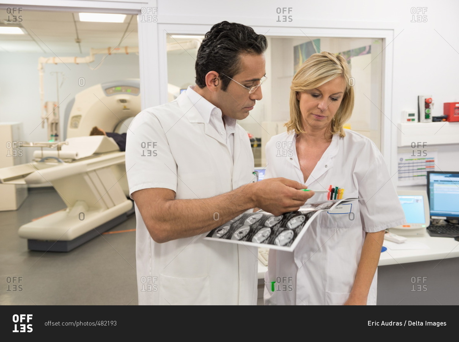 Doctors examining MRI scan report in medical scan room