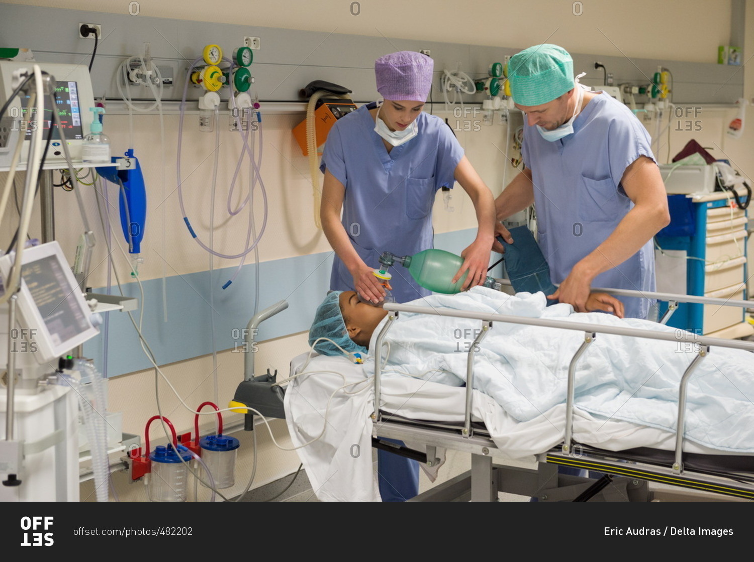 doctor-and-nurse-giving-oxygen-to-patient-in-recovery-room-stock-photo