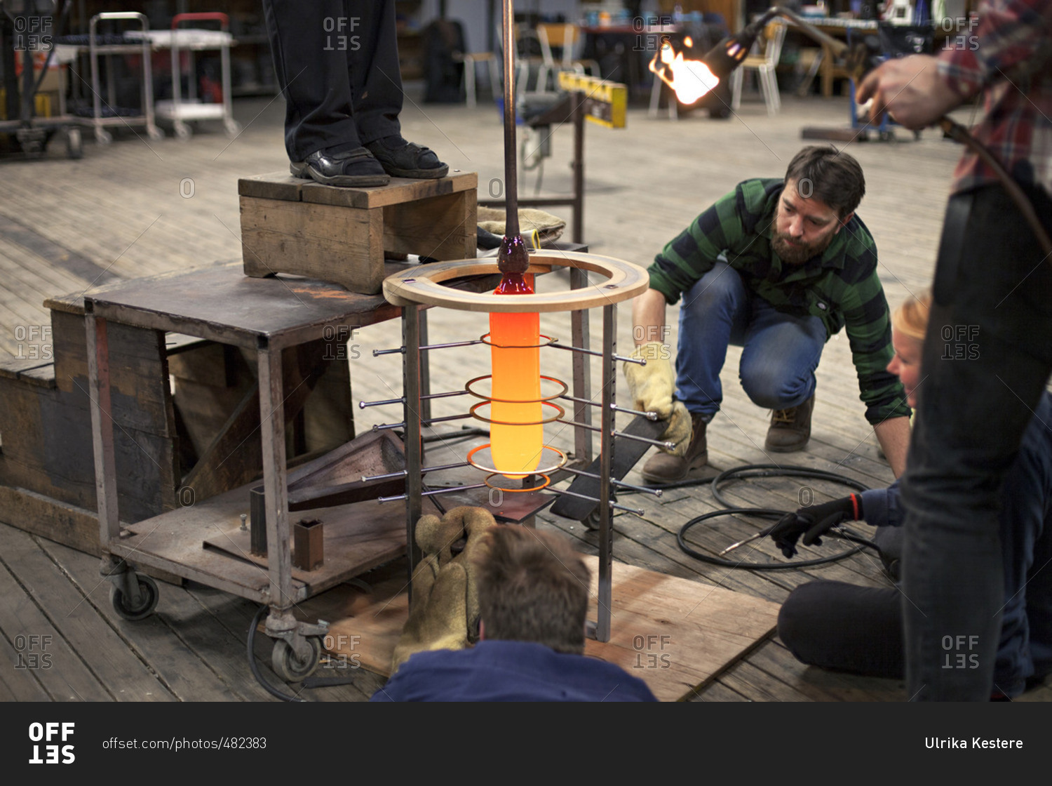 Glass makers shaping a glass piece