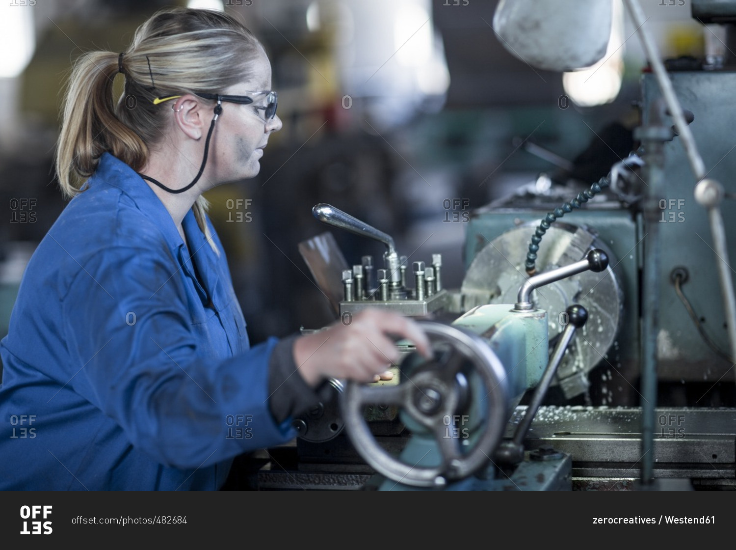Woman operating machine in workshop