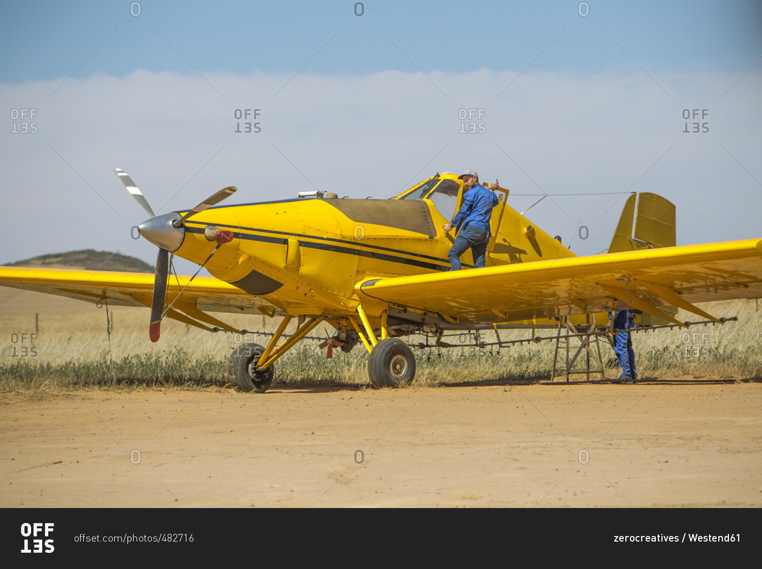 Mechanics preparing yellow crop dusting plane