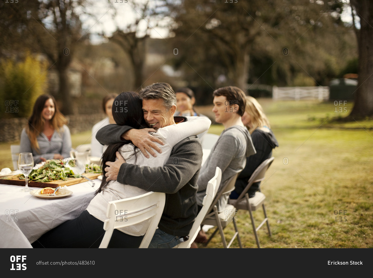 Friends hugging during an outdoor dinner party
