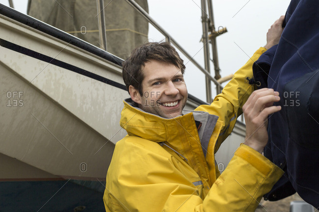Man in a raincoat tending to his boat