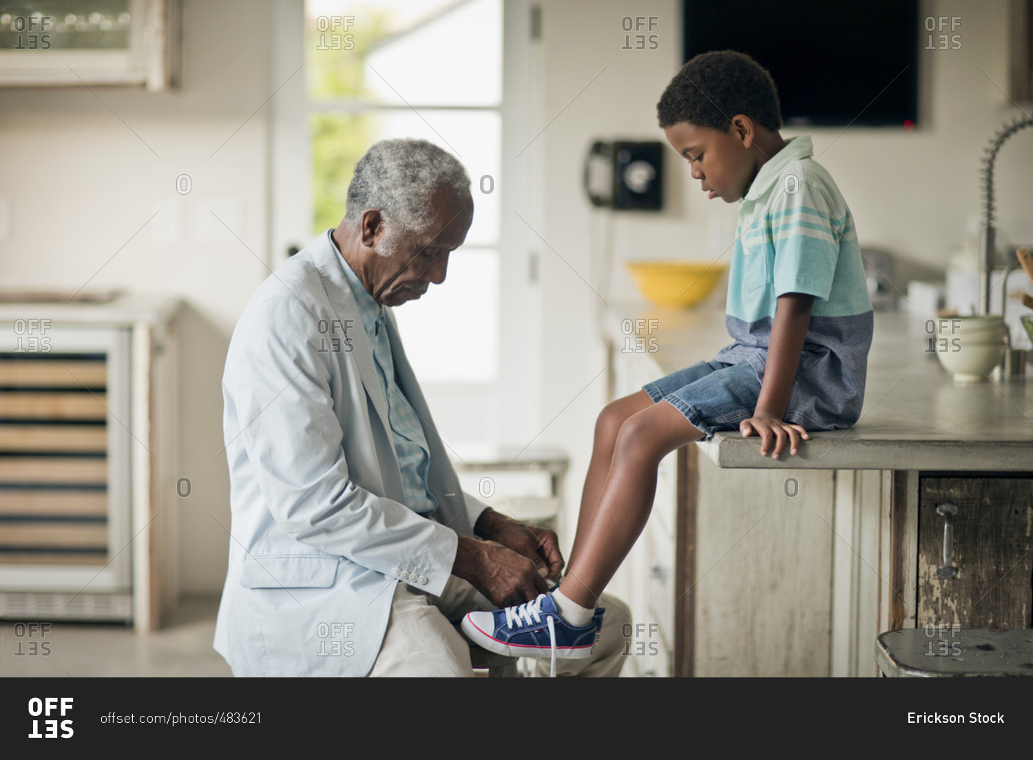 Grandfather helping his grandson to tie his shoelaces