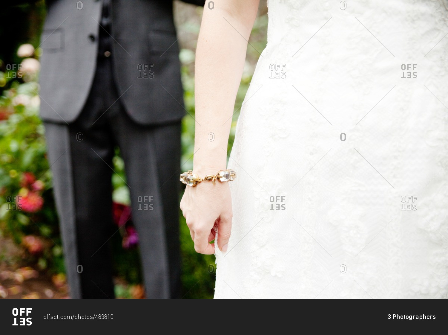 Groom standing behind a bride with a gold and crystal bracelet