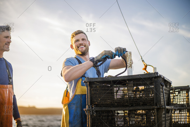 Fisherman catching lobsters on a boat.