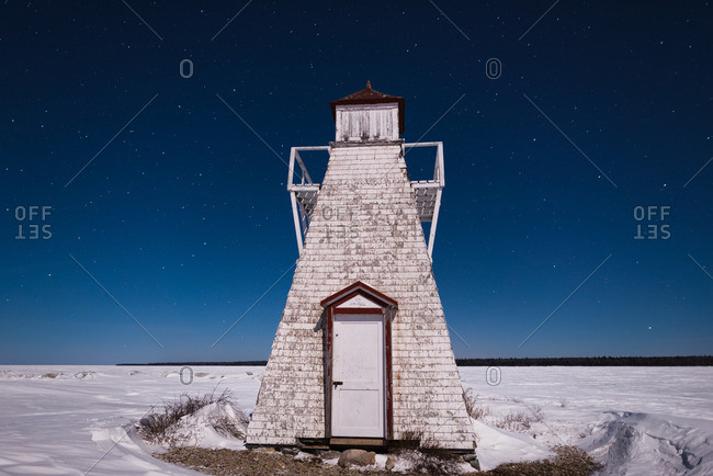 Nighttime over abandoned lighthouse in winter