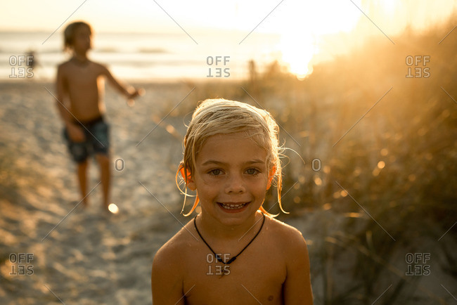 Boys playing on a beach at sunset