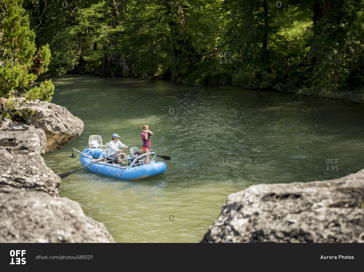 A Woman Fly Fishing For Rainbow Trout While Man Riding Dinghy On Guadalupe River