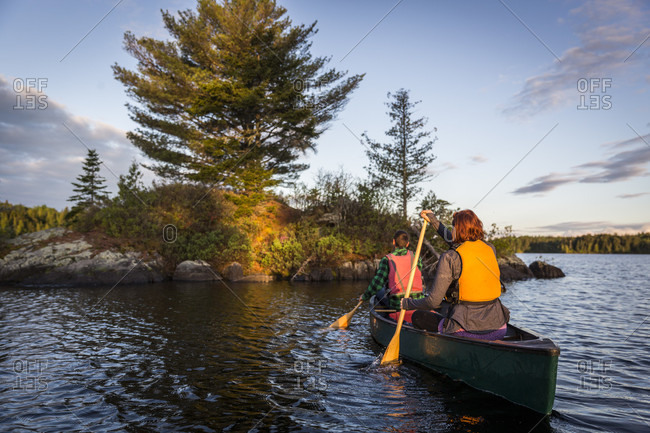 A Young Couple Paddles A Canoe On Long Pond In Maine's North Woods Near Greenville, Maine