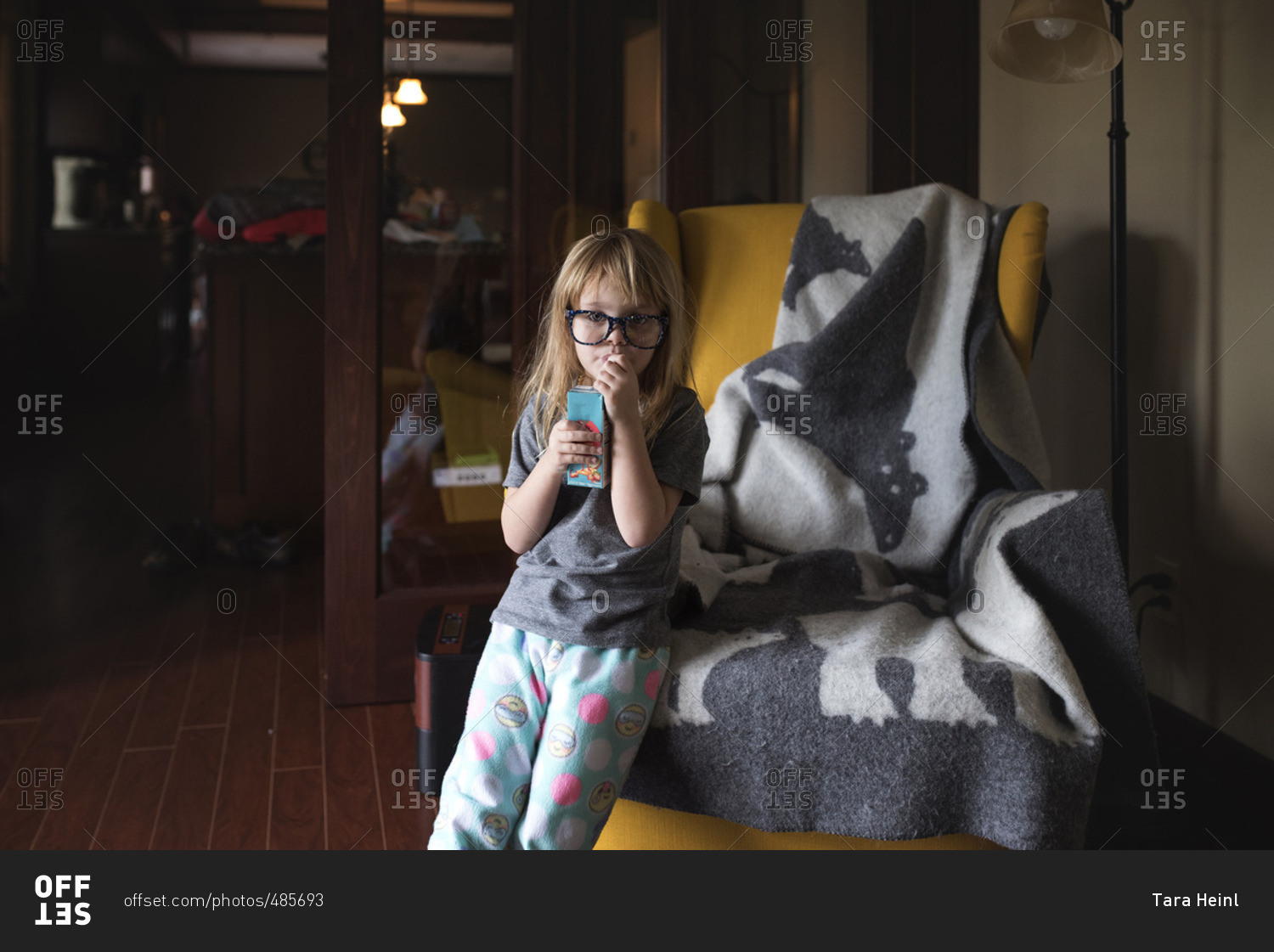 Girl in glasses drinking from juice box