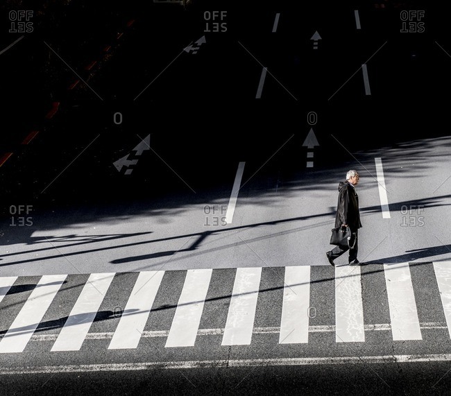 Tokyo, Japan - December 3, 2016: Businessman walking on crosswalk in Tokyo, Japan after work