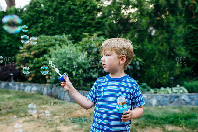 Boy watching bubbles from wand