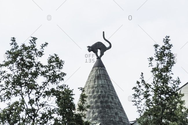 A sculpture of a cat on top of the cat house