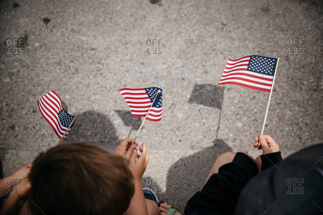 Overhead view of children holding American flags at parade