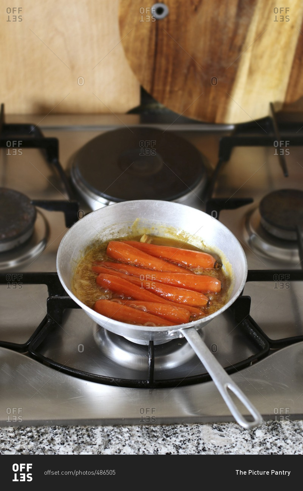 Honey glazed Carrots in pan simmering in freshly squeezed orange juice to glaze