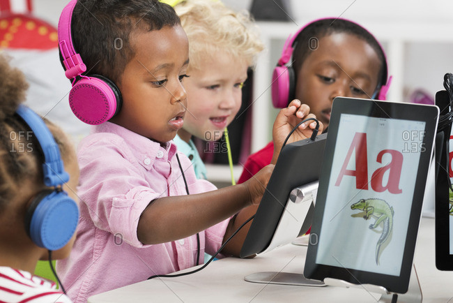 Students learning alphabet with digital tablets