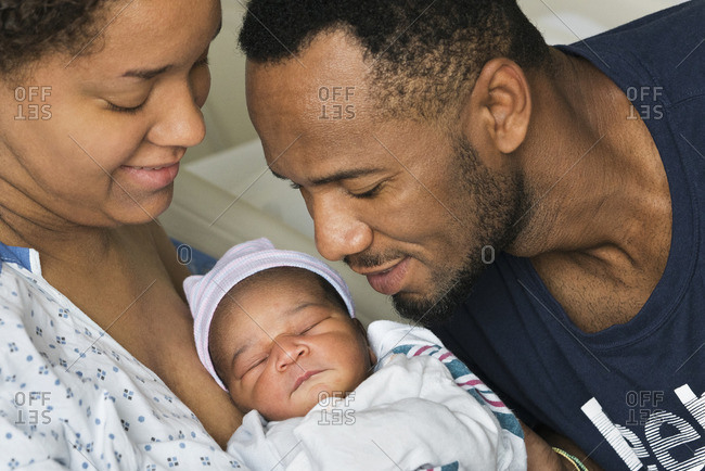 Black parents admiring newborn son in hospital