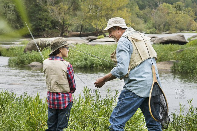 Grandfather teaching fishing to grandson