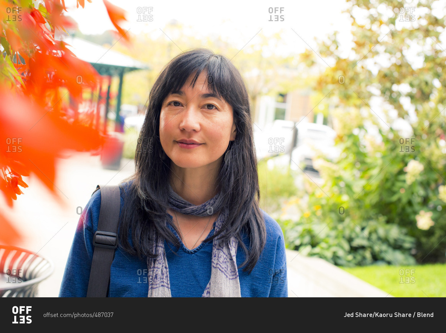 Japanese woman smiling near autumn leaves