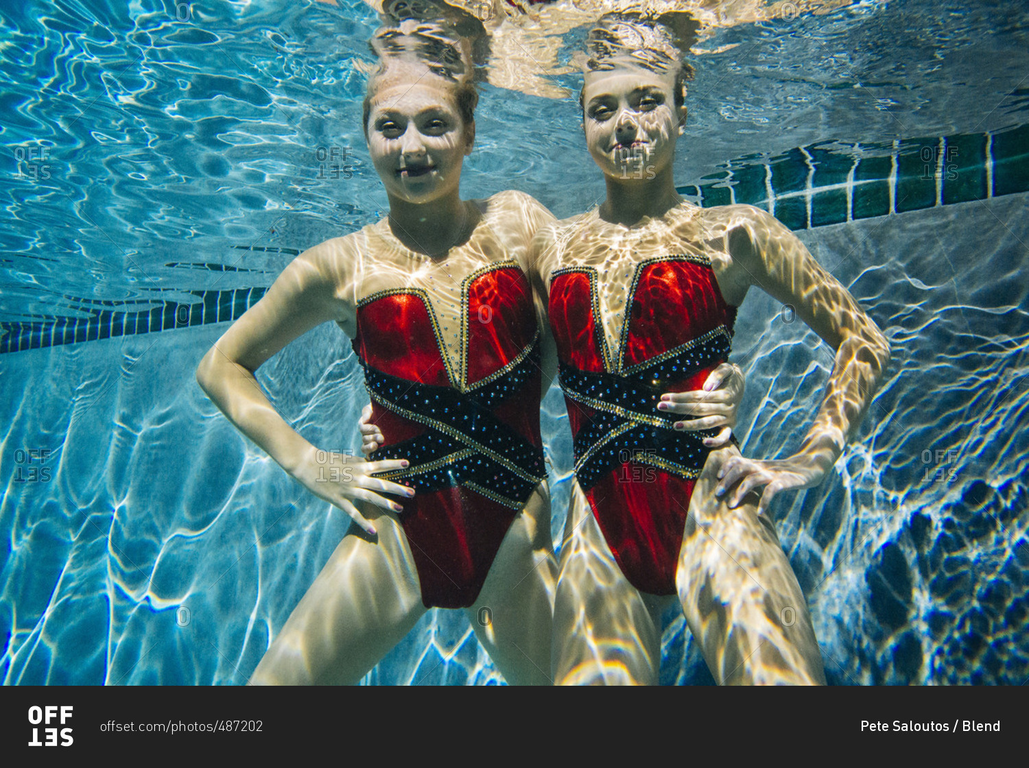 Portrait of synchronized swimmers smiling underwater stock photo - OFFSET