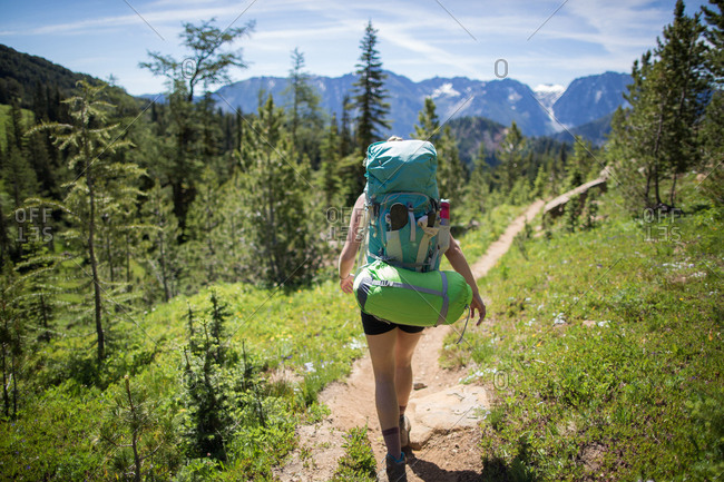 Hiker walking across forest, Enchantments, Alpine Lakes Wilderness, Washington, USA