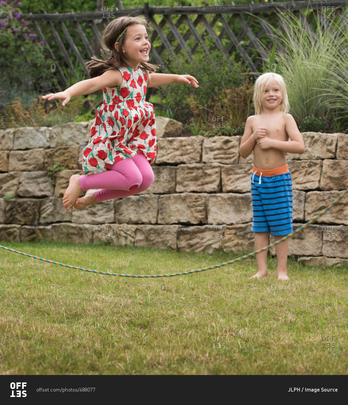 Girl playing with skipping rope jumping in mid air stock photo OFFSET